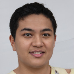 Joyful latino young-adult male with short  brown hair and brown eyes