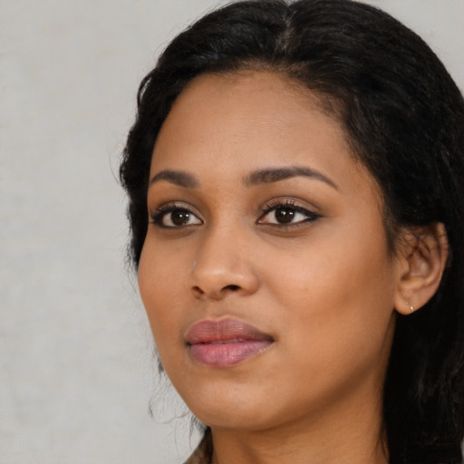 Joyful black young-adult female with long  black hair and brown eyes