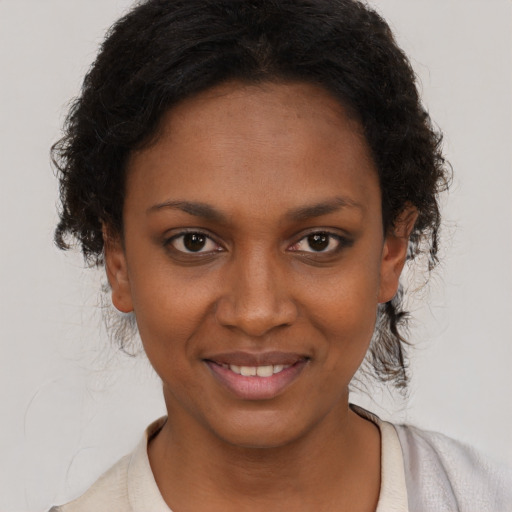 Joyful black young-adult female with short  brown hair and brown eyes