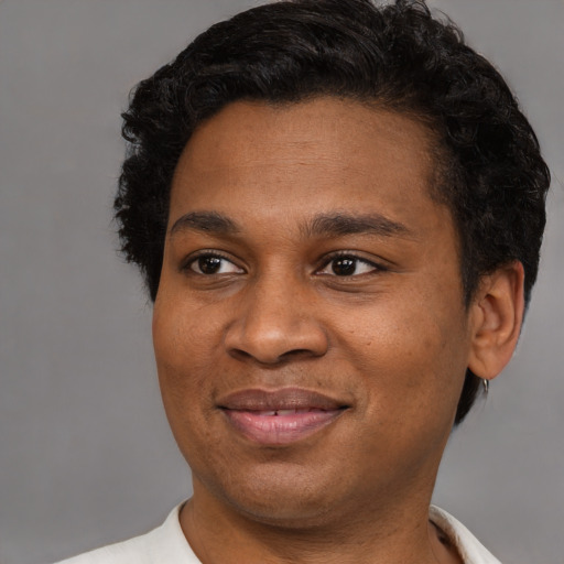 Joyful black adult male with short  brown hair and brown eyes
