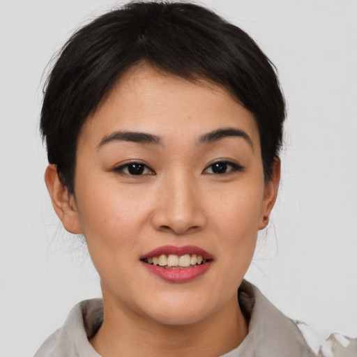 Joyful asian young-adult female with short  brown hair and brown eyes