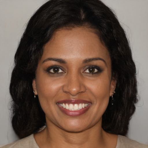 Joyful black young-adult female with medium  brown hair and brown eyes