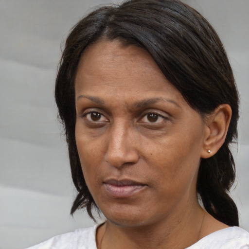 Neutral latino adult female with medium  brown hair and brown eyes