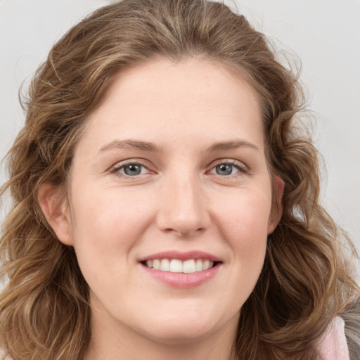 Joyful white young-adult female with long  brown hair and grey eyes