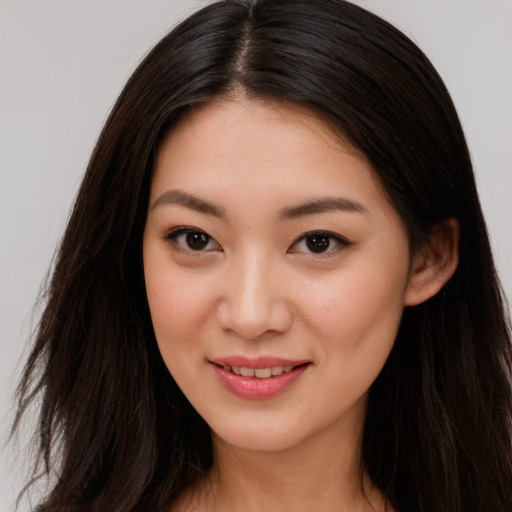Joyful asian young-adult female with long  brown hair and brown eyes