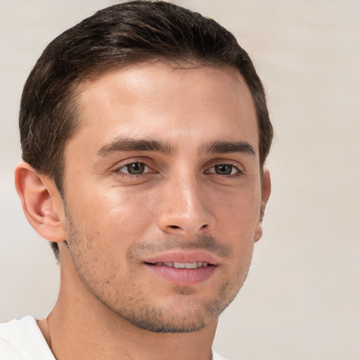 Joyful white young-adult male with short  brown hair and grey eyes