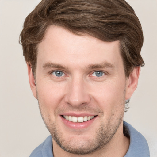 Joyful white young-adult male with short  brown hair and grey eyes