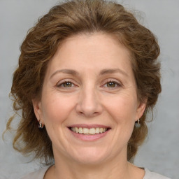 Joyful white adult female with medium  brown hair and green eyes