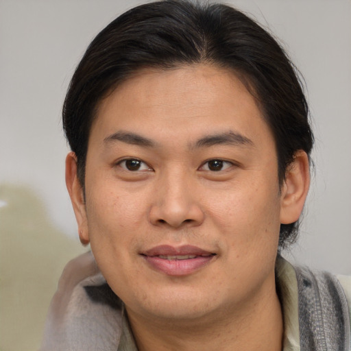 Joyful asian young-adult male with short  brown hair and brown eyes