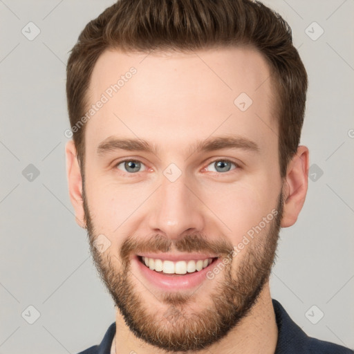 Joyful white young-adult male with short  brown hair and grey eyes