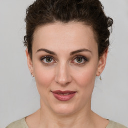 Joyful white young-adult female with medium  brown hair and green eyes