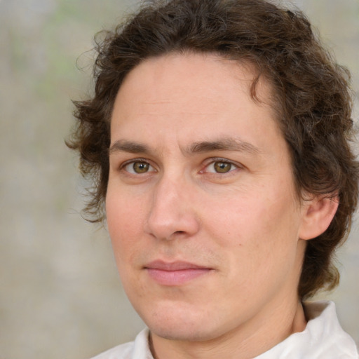 Joyful white young-adult male with medium  brown hair and green eyes