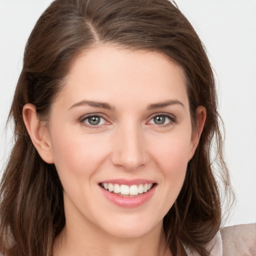 Joyful white young-adult female with long  brown hair and grey eyes