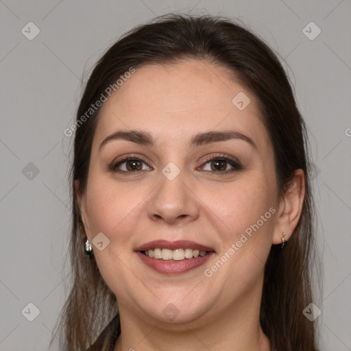 Joyful white young-adult female with long  brown hair and brown eyes