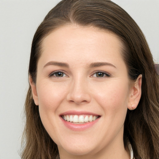 Joyful white young-adult female with long  brown hair and grey eyes