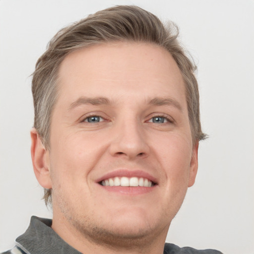 Joyful white adult male with short  brown hair and grey eyes