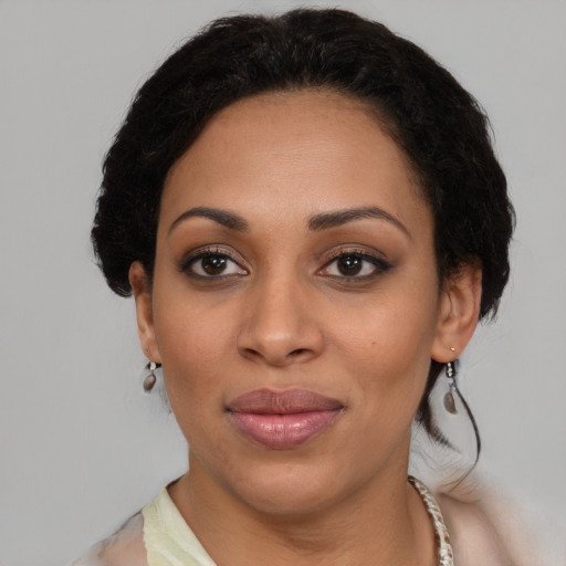 Joyful black adult female with medium  brown hair and brown eyes