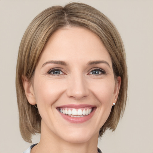 Joyful white young-adult female with medium  brown hair and green eyes