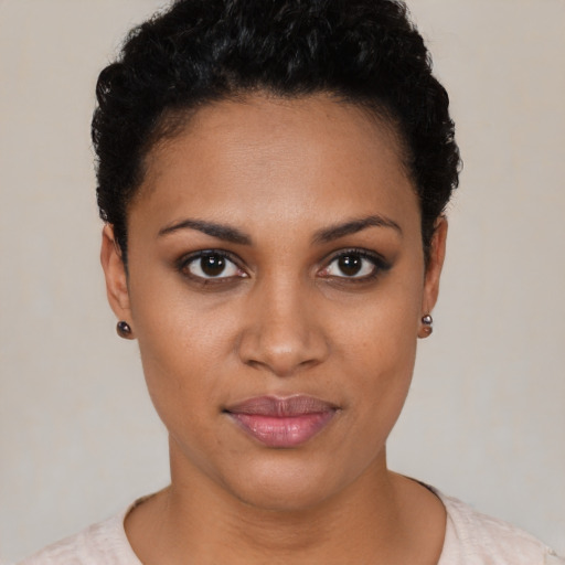 Joyful black young-adult female with short  black hair and brown eyes