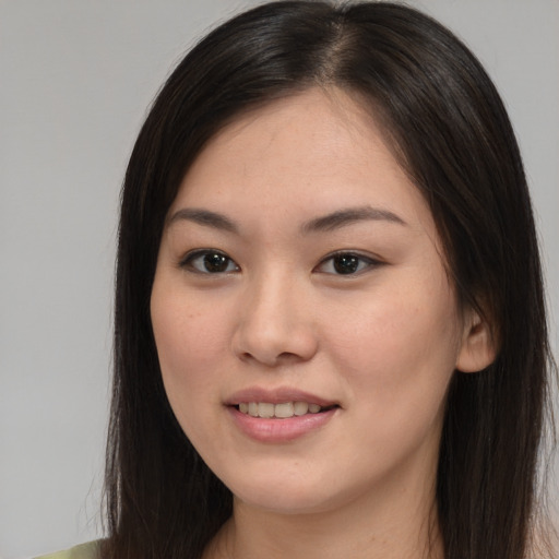 Joyful asian young-adult female with long  brown hair and brown eyes