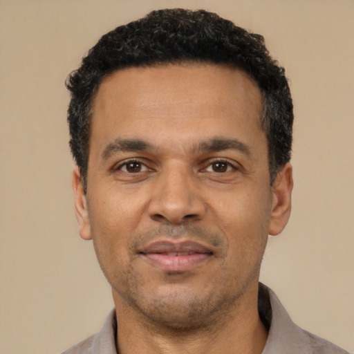 Joyful latino adult male with short  black hair and brown eyes