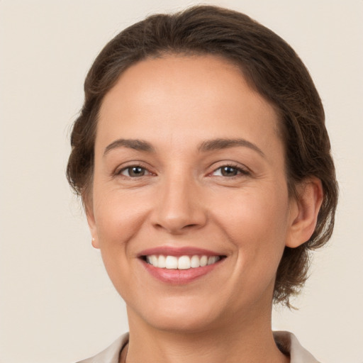 Joyful white young-adult female with medium  brown hair and brown eyes