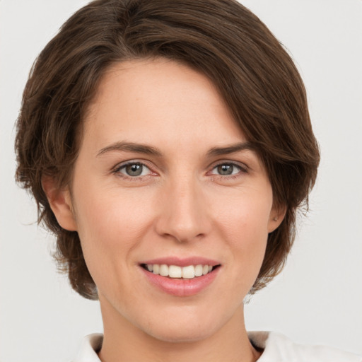 Joyful white young-adult female with medium  brown hair and grey eyes