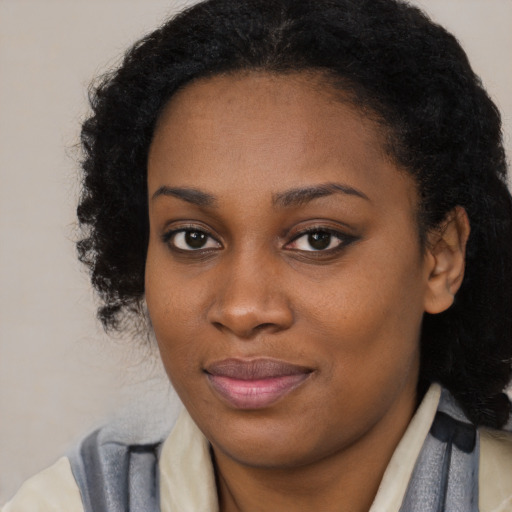Joyful black young-adult female with long  brown hair and brown eyes