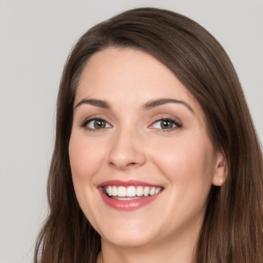 Joyful white young-adult female with long  brown hair and brown eyes