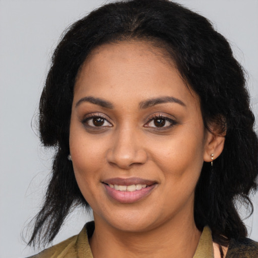 Joyful black young-adult female with long  brown hair and brown eyes
