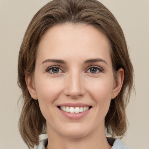 Joyful white young-adult female with medium  brown hair and green eyes