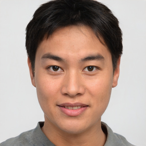 Joyful asian young-adult male with short  brown hair and brown eyes