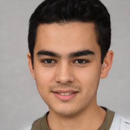 Joyful latino young-adult male with short  brown hair and brown eyes