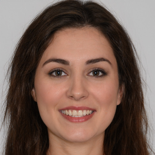 Joyful white young-adult female with long  brown hair and brown eyes