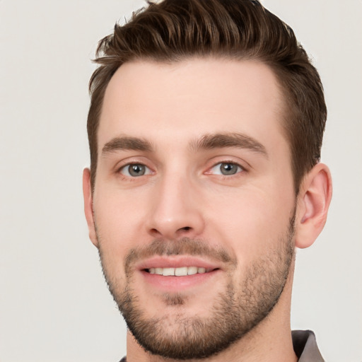 Joyful white young-adult male with short  brown hair and grey eyes