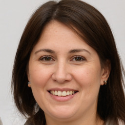 Joyful white adult female with long  brown hair and brown eyes