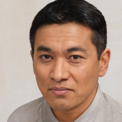 Joyful asian adult male with short  black hair and brown eyes