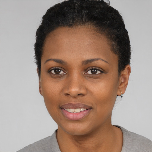 Joyful black young-adult female with short  black hair and brown eyes