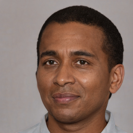 Joyful black adult male with short  black hair and brown eyes