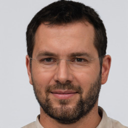 Joyful white adult male with short  brown hair and brown eyes