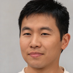 Joyful asian young-adult male with short  black hair and brown eyes