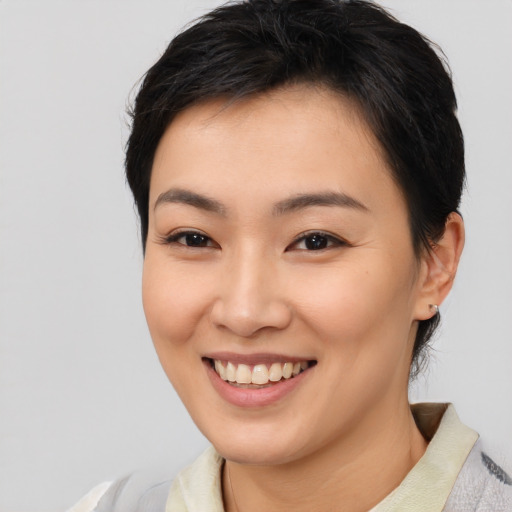 Joyful asian young-adult female with short  black hair and brown eyes