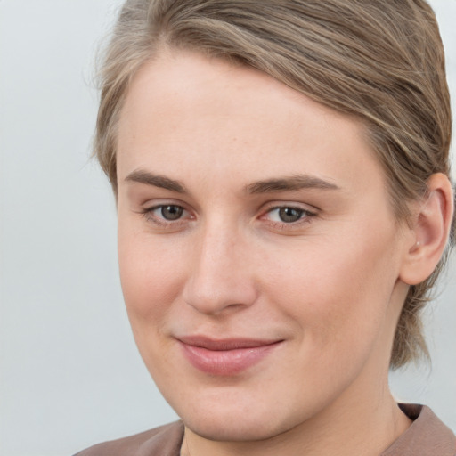 Joyful white young-adult female with medium  brown hair and grey eyes