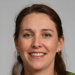 Joyful white adult female with medium  brown hair and grey eyes