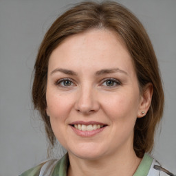 Joyful white adult female with medium  brown hair and grey eyes