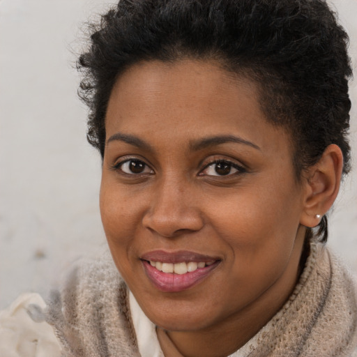 Joyful black young-adult female with short  brown hair and brown eyes
