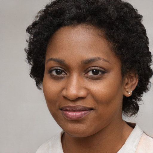 Joyful black young-adult female with medium  brown hair and brown eyes