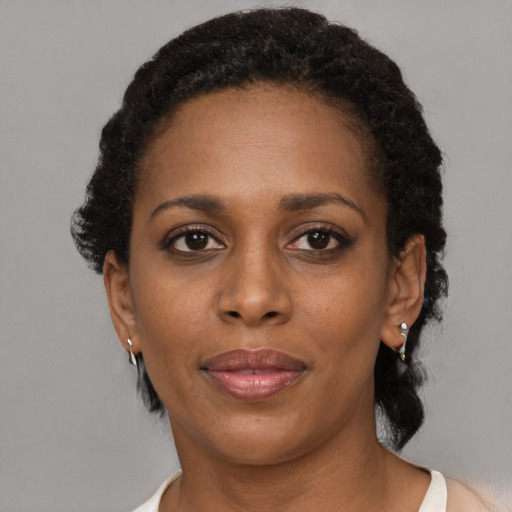 Joyful black adult female with short  brown hair and brown eyes