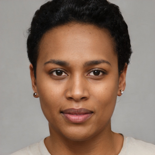 Joyful black young-adult female with short  black hair and brown eyes
