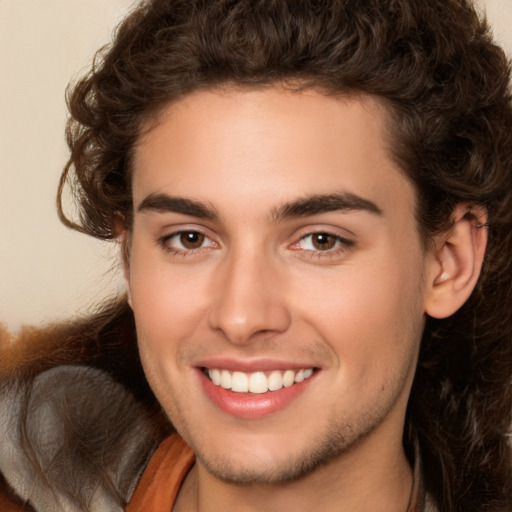 Joyful white young-adult male with long  brown hair and brown eyes